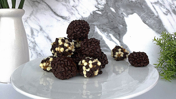 Chocolate and Sticky Date Delite Bites on a white plate with a marble background