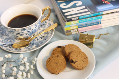 Delicious cookies on plate with cup of tea