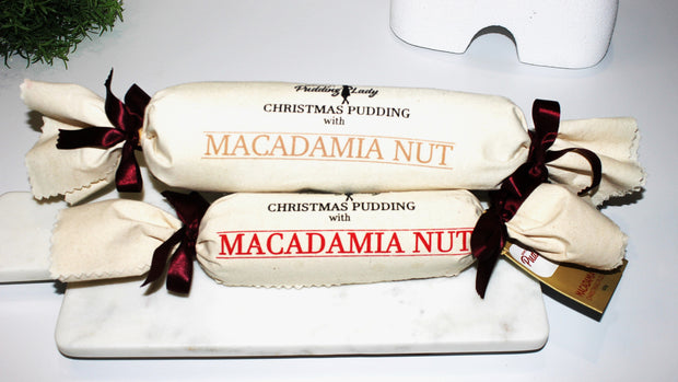 pudding log with macadamia wrapped in calico on white kitchen bench top two sizes 
