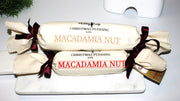 Two sizes of macadamia nut traditional pudding log wrapped in calico on a marble board