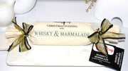 Whisky & Marmalade log pudding decorated with calico and ribbon on a marble plate