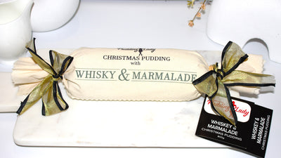Whisky & Marmalade log pudding decorated with calico and ribbon on a marble plate