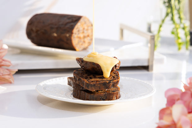 Macadamia nut pudding and cream on a white plate, with a blurred background
