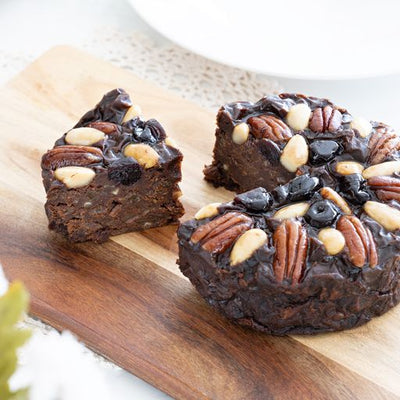 Pudding Lady Chocolate Fruitcake with a piece served on wooden board