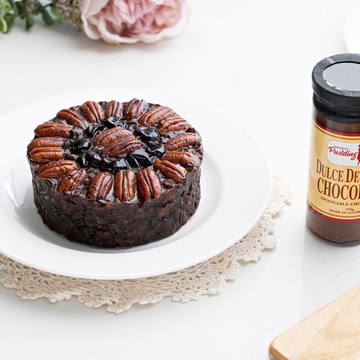 Pudding Lady chocolate & Pecan cake plated next to chocolate sauce jar - unique gift