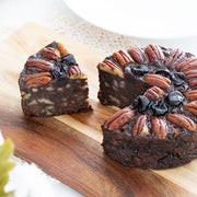 Close up of Pudding Lady chocolate & Pecan cake sliced on wooden board - great gifte sauce jar - unique gift